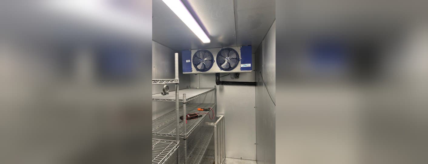 Walk-in cooler evaporator being serviced by ALAS